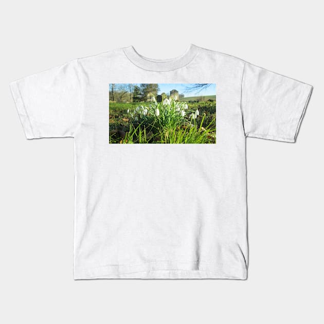 Fully Bloomed Snowdrops in Churchyard Kids T-Shirt by Natural Distractions